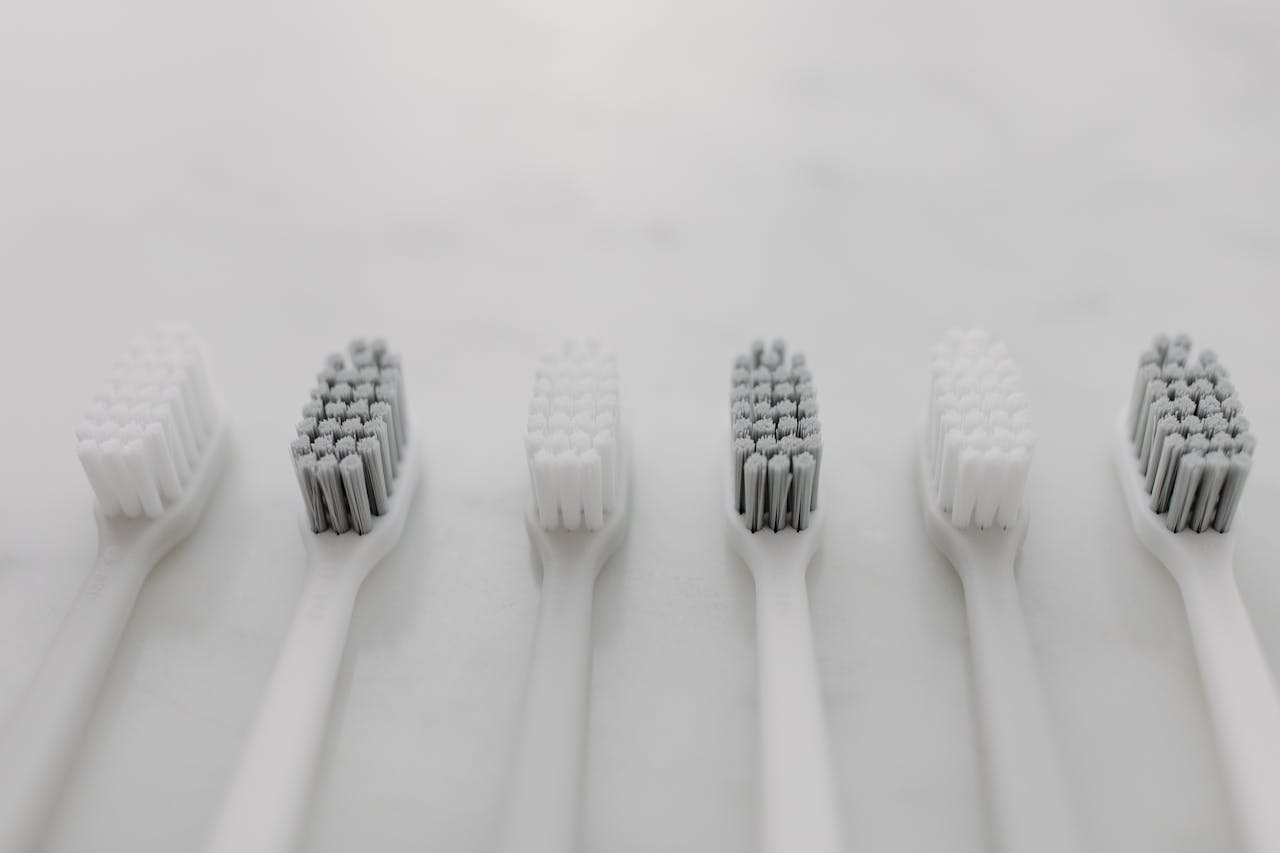 A clean and minimalist flat lay of toothbrushes on a marble surface for oral hygiene.