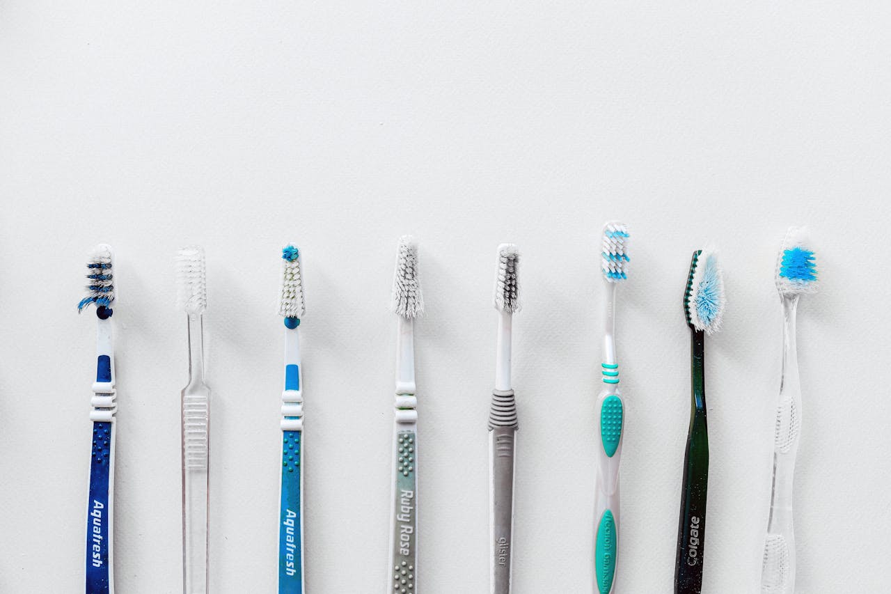 Diverse selection of toothbrushes lined up for dental hygiene focus with copy space.